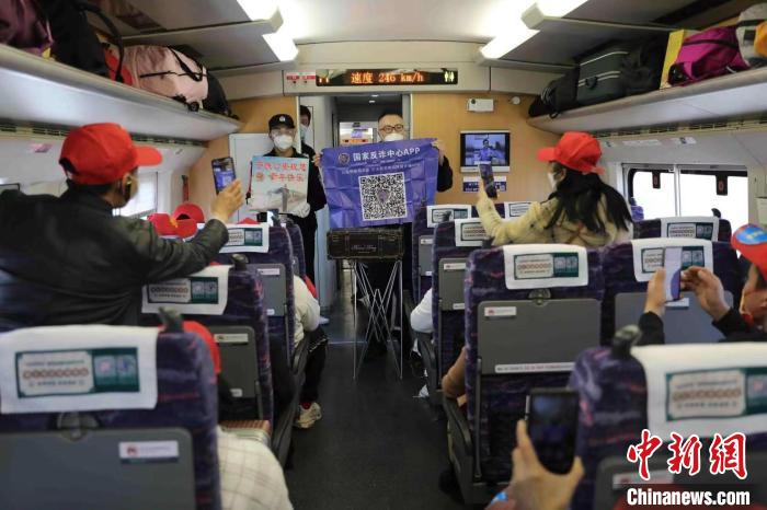 “警营魔术师”秦国平利用魔术宣传推广“国家反诈中心”APP，外出务工旅客纷纷拿出手机扫码安装。　 冉景嘉 摄